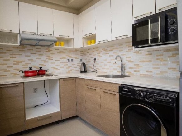 Functional kitchen with modern appliances in a Kridari apartment.